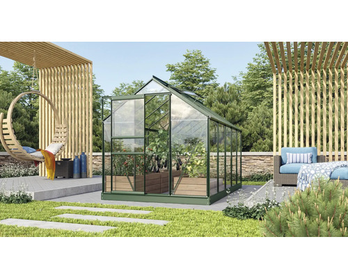 Gewächshaus im Garten mit Pflanzen und Gartenmöbeln