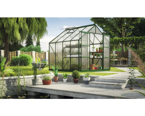 Gewächshaus mit Regalen in einem Garten mit Teich