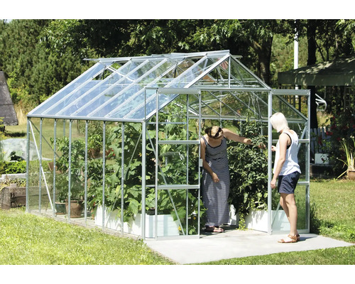 Gewächshaus mit Pflanzen und zwei Personen im Garten