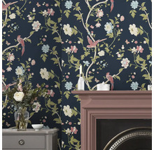 Raumansicht mit floraler Tapete, Kamin und Kommode