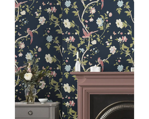 Raumansicht mit floraler Tapete, Kamin und Kommode