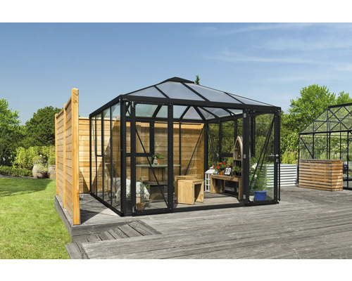 Gewächshaus mit Glaswänden und Holzinterieur im Garten.