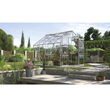 Gewächshaus im Garten mit Pflanzen und Gartenmöbeln