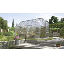 Gewächshaus mit transparenten Wänden in einem Garten mit Bepflanzung und Terrasse