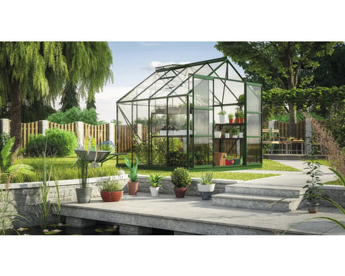 Gewächshaus im Garten mit Pflanzen und Gartengeräten