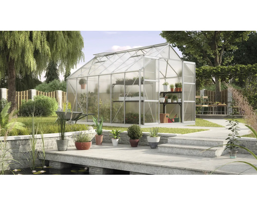 Gewächshaus im Garten mit Pflanzenregalen und Teichanlage