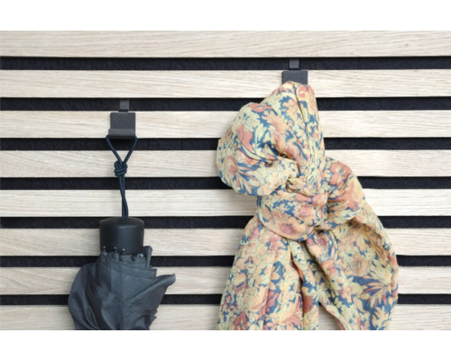 Wandpaneel mit Haken, an denen ein Regenschirm und ein Schal hängen