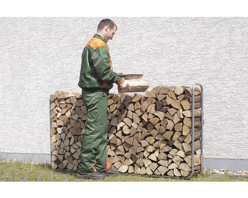 Mann legt Holz in ein Holzregal