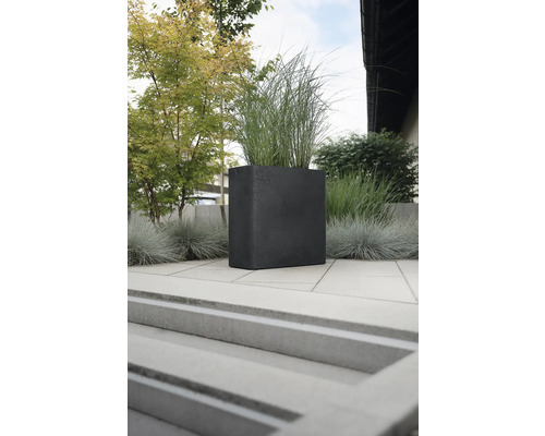 Quadratischer Pflanzkübel aus Stein mit Bepflanzung im Außenbereich.