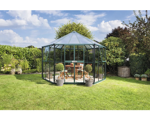 Achteckiges Gartenhaus aus Glas und Metall im Garten mit Tisch und Stühlen