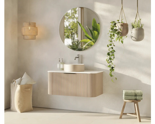 Badezimmer mit Waschtisch, Spiegel, Hängepflanzen, Lampe und Wäschekorb für ein helles und organisiertes Ambiente.