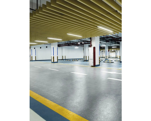 Innenaufnahme einer Tiefgarage mit Betonboden, Säulen und Deckenverkleidung.