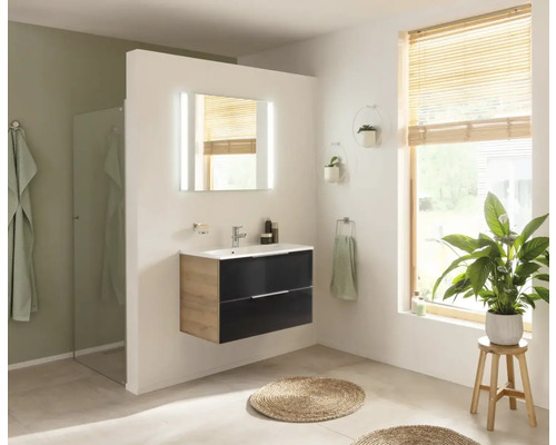 Helles Badezimmer mit Waschbeckenunterschrank, Spiegel mit Beleuchtung und Pflanze