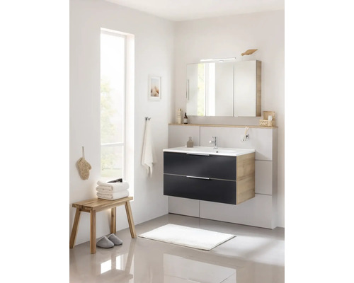 Helles Badezimmer mit Waschtisch, Spiegelschrank, Hocker, Handtüchern und Badteppich.