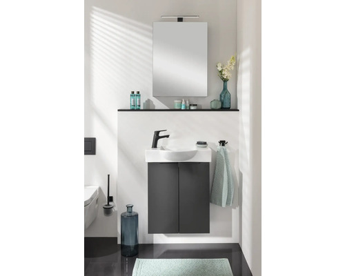 Badezimmer mit Waschbecken, Unterschrank, Spiegel und Ablagefläche