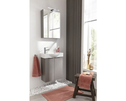 Modernes Badezimmer mit Waschbeckenunterschrank, Spiegelschrank und dekorativen Elementen