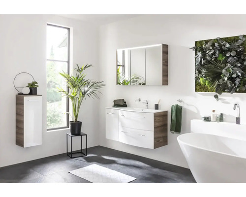 Modernes Badezimmer mit Waschtisch, Spiegelschrank, Hängeschrank und Badewanne für ein helles und geräumiges Ambiente.