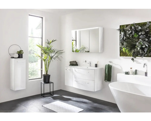 Helles Badezimmer mit Badewanne, Waschtisch, Spiegelschrank, Hängeschrank und Dekorationen.