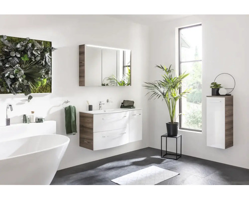 Badezimmer mit Badewanne, Waschtisch, Spiegelschrank und Wandschrank in hellem Design