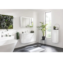 Helles Badezimmer mit Badewanne, Waschtisch, Spiegelschrank und Pflanzen