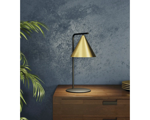 Goldfarbene Tischleuchte auf einem Nachttisch