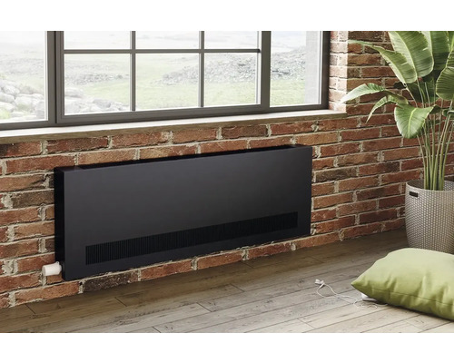 Schwarzer Heizkörper an Ziegelwand unter Fenster