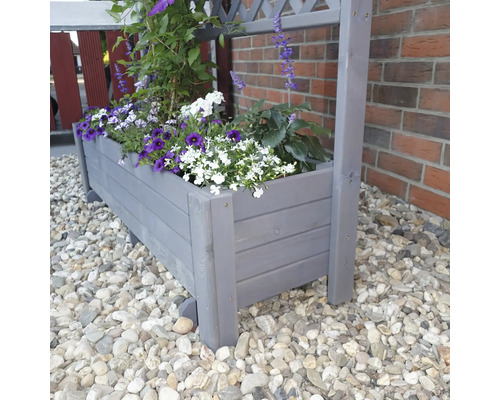 Grauer Pflanzkasten aus Holz mit blühenden Pflanzen