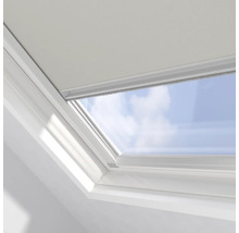 Detailansicht eines Dachfensters mit Rollo vor blauem Himmel