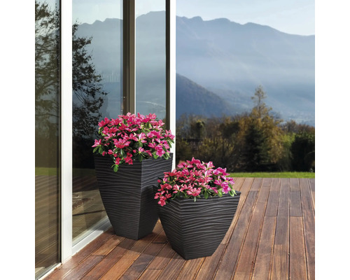 Zwei strukturierte Pflanzkübel mit Pflanzen auf einer Terrasse