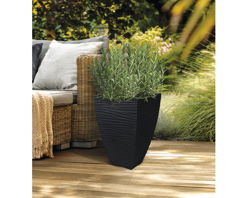 Schwarzer Pflanzkübel mit Strukturmuster und grüner Pflanze auf einer Holzterrasse