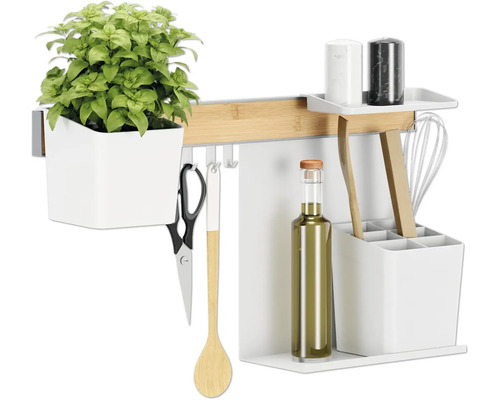 Küchenutensilien an einer Hängeleiste mit Kräutertopf, Ölflasche und Schneebesen