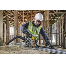 Ein Arbeiter benutzt eine Tauchsäge auf einer Holzplatte, umgeben von einem Holzrahmen