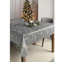 Festlich gedeckter Tisch mit grauer Tischdecke mit Hirschmuster im weihnachtlich dekorierten Raum.