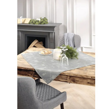 Dekorativer Esstisch mit Tischläufer, Gedeck und Kamin im Hintergrund.