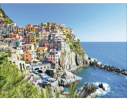 Ansicht von Manarola, einem Küstenort in Italien, mit farbenfrohen Häusern auf einer Klippe über dem Meer.
