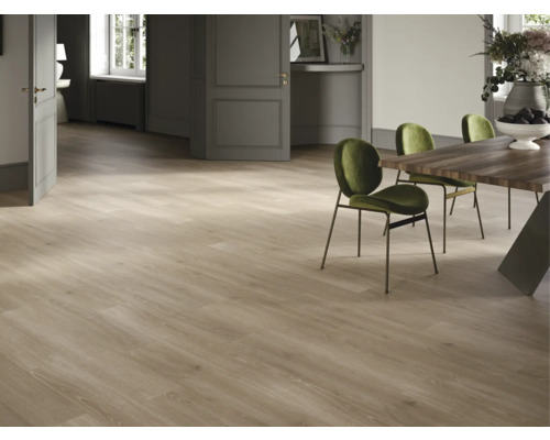 Heller Raum mit Holzboden, Esstisch und grünen Stühlen.