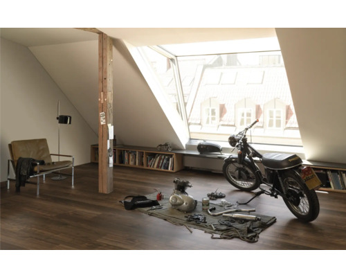 Dachzimmer mit Dachfenster, Sessel, Bücherregal und Motorrad zur Reparatur