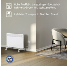 Weißer Konvektor-Heizkörper mit Rollen und TÜV Süd Siegel in einem Raum