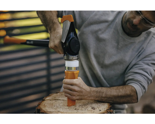 Ein Mann benutzt einen Holzspalter auf einem Holzscheit