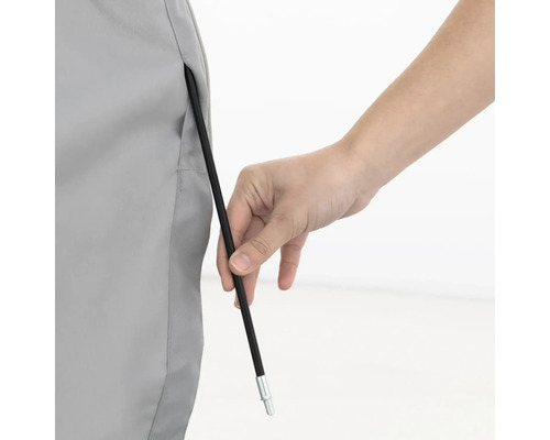 Person führt einen Zeltstab durch eine Stofföse