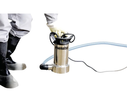 Eine Person bedient eine Metabo Schmutzwasserpumpe mit Schlauch und Kabel.