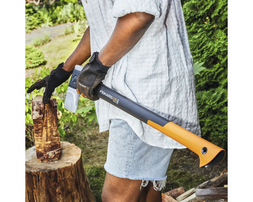 Person spaltet Holz mit einer Fiskars X28 Spaltaxt