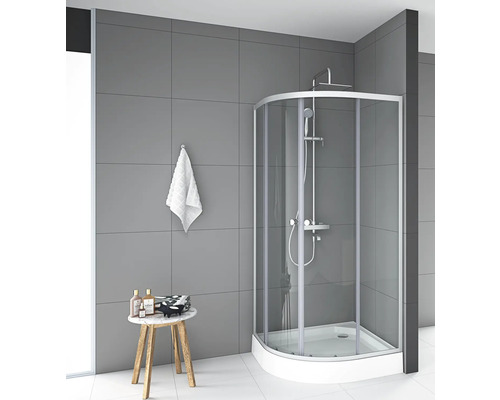 Eckdusche mit Duschkopf und Armatur in einem Badezimmer mit grauen Fliesen