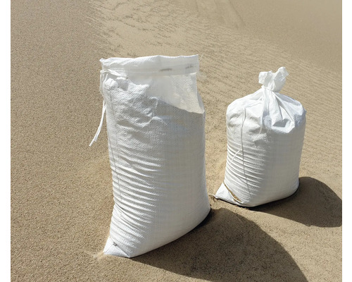 Zwei Sandsäcke aus Kunststoff auf sandigem Untergrund