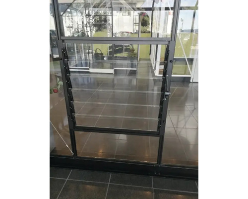 Detailansicht eines Gewächshauses mit einem Fenster mit Lamellen