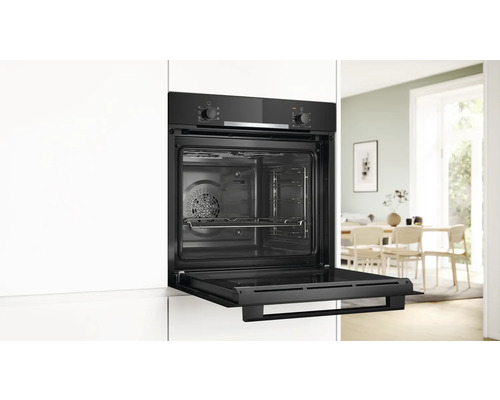 Einbauofen mit geöffneter Tür in einer Küche.