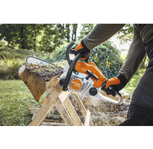Person sägt Holzscheit mit Stihl Motorsäge auf Holzbock