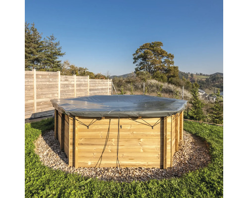 Runder Pool mit Holzverkleidung und Abdeckung im Garten