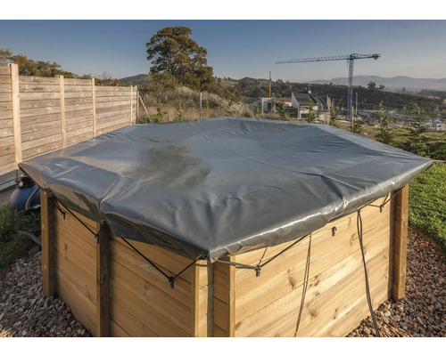 Abgedeckter Pool mit Holzverkleidung und grauer Plane im Außenbereich