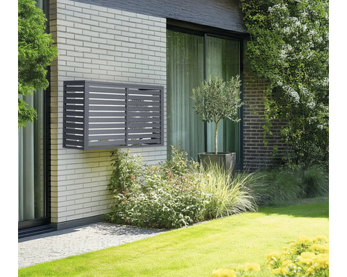 Graue Klimaanlagenverkleidung an einer Hauswand mit Ziegeln
